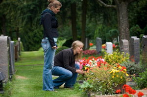 Photo of grieving sisters at a cemetery