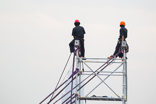 Construction workers working on scaffolds