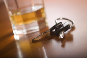 Photo of keys next to a glass of alcohol