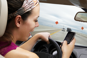 Photo of a person texting while driving