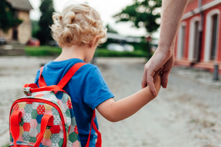 The parent holds the hand of a small child