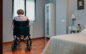 Senior woman in a wheelchair alone in a room