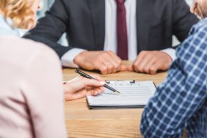 Family Law Lawyer Rockland County, NY with two people sitting at desk in front of a man in a suit reviewing paperwork